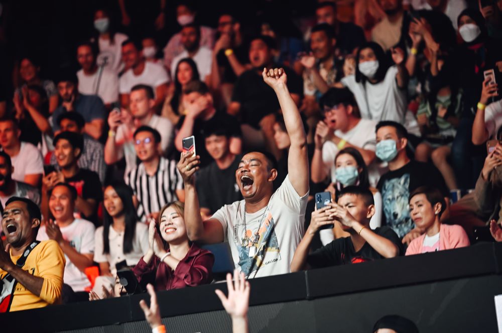 Spectators cheering during a Muay Thai fight