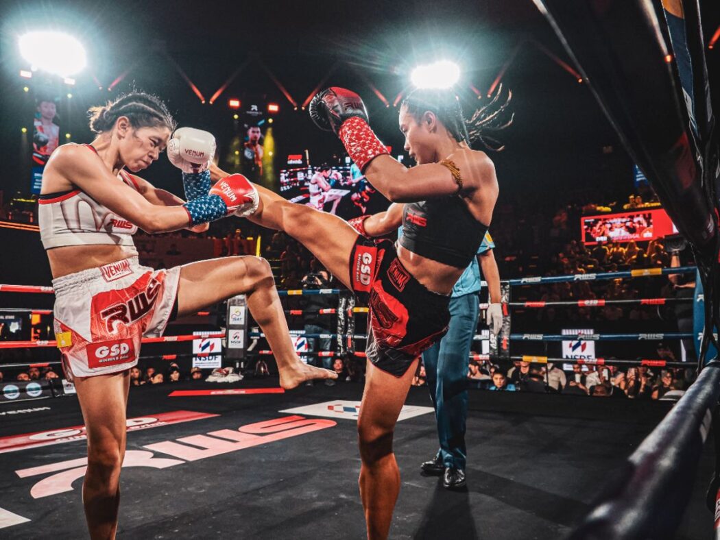 Female Muay Thai fighters in the ring.