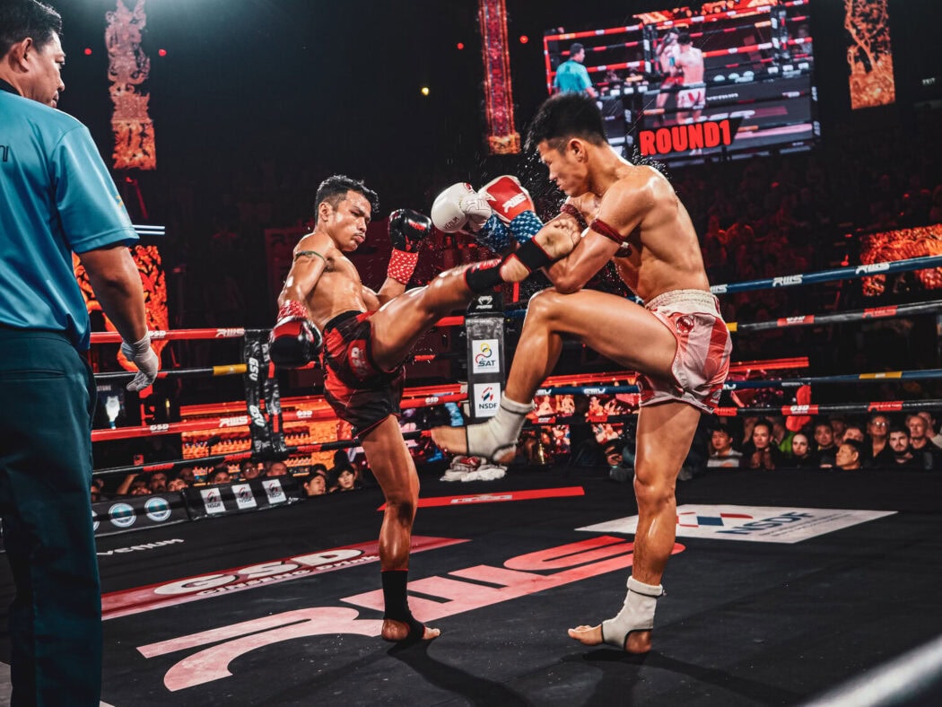 Two fighters using muay thai self defense techniques in Rajadamnern Stadium