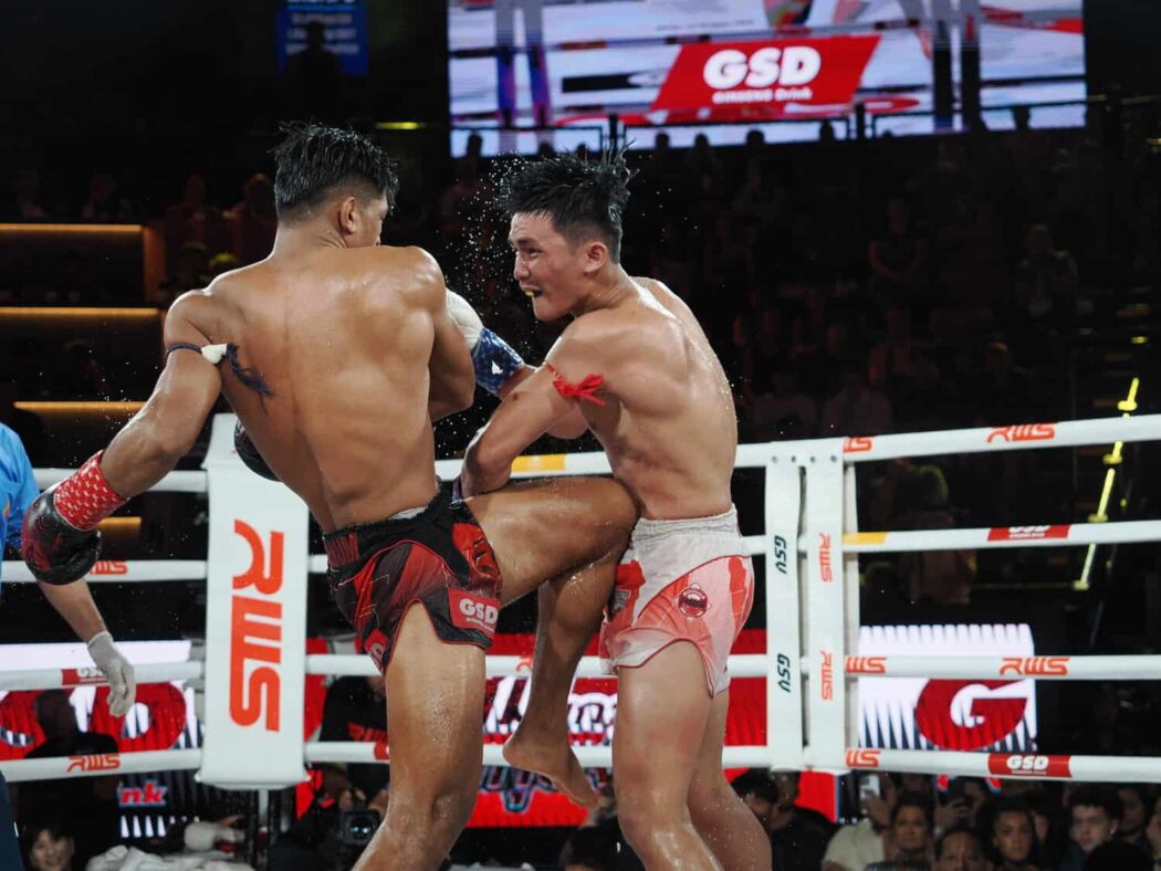 Muay Thai fighter lands a knee stroke against an opponent
