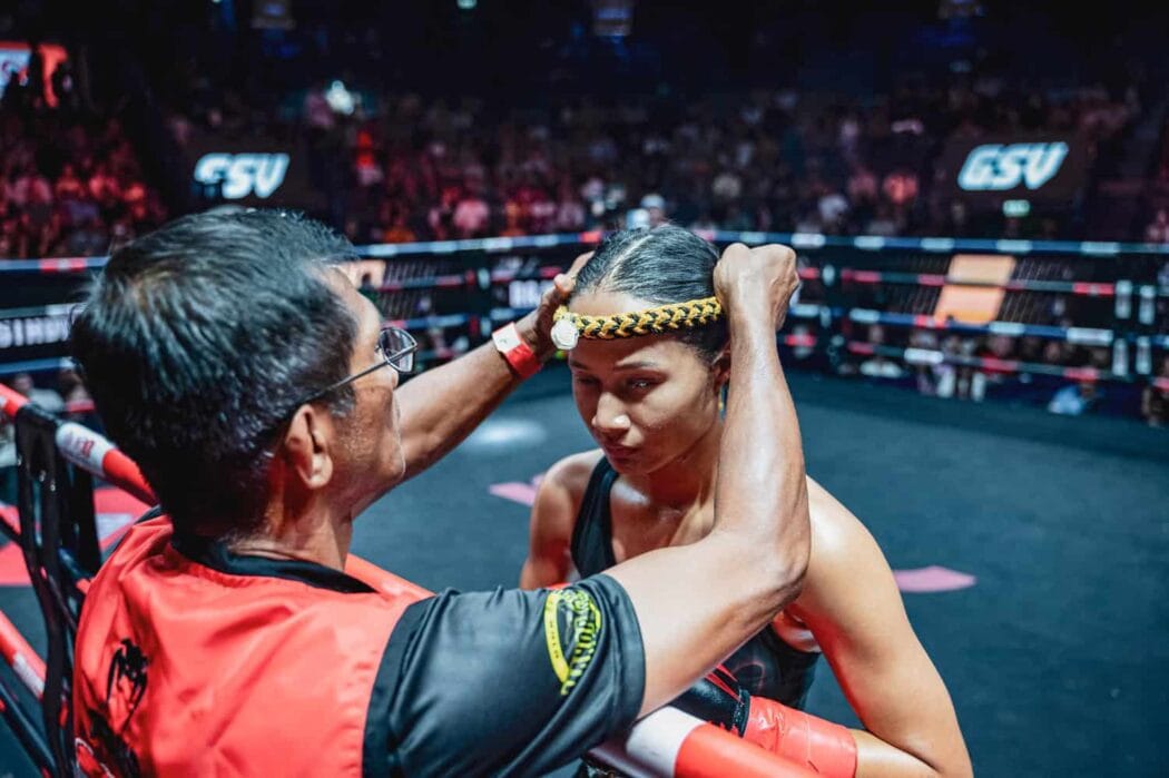Muay Thai coach dons a Mongkol on his fighter’s head