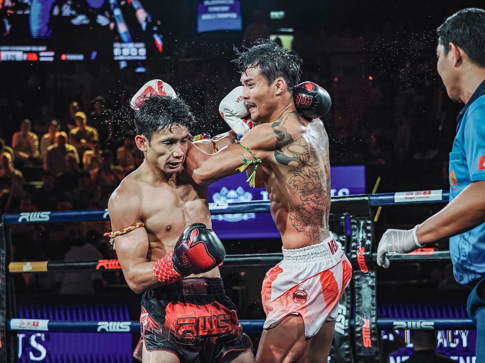 a muay thai fighter dodges a strike while delivering an elbow counterstrike