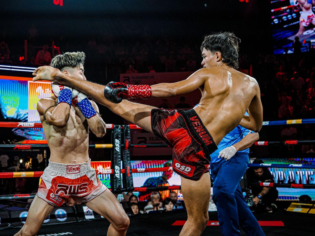 A Muay Thai trainer encourages a practitioner in the ring side